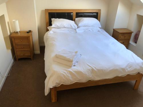 a large bed with white sheets and towels on it at Jo's House in Walsall
