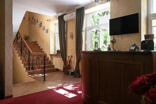 a living room with a staircase and a television at Conviva in Panevėžys