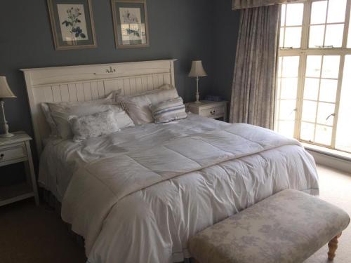 sypialnia z dużym łóżkiem z białą kołdrą w obiekcie Rose Cottage @ Gods' Haven Eco Estate w mieście Underberg