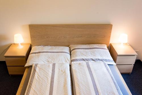 a bedroom with two beds and two night stands at Apartmány Na náměstí in Boží Dar