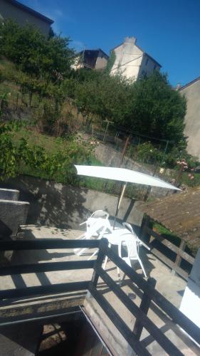ein weißer Regenschirm auf einem Tisch in der Unterkunft T2 tout confort avec terrasse in Cransac