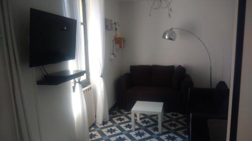 ein Wohnzimmer mit einem Sofa und einem Flachbild-TV in der Unterkunft T2 tout confort avec terrasse in Cransac