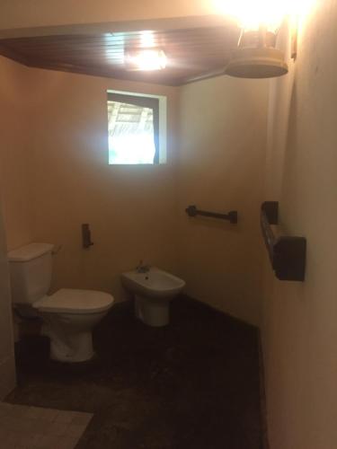 a bathroom with a toilet and a sink and a window at Severin Safari Camp in Tsavo West National Park