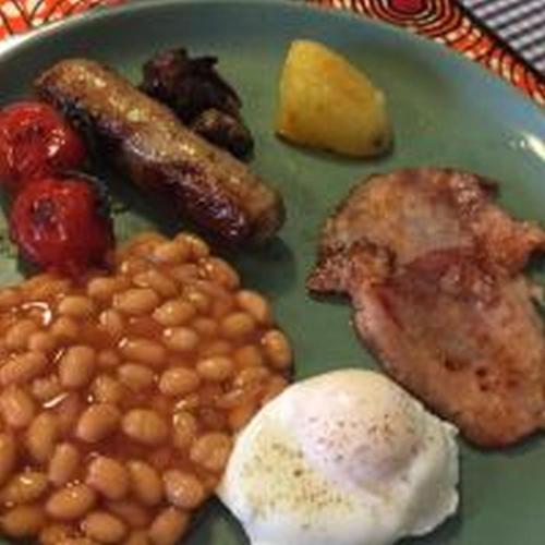 达累斯萨拉姆Mikocheni Condo Hotel & Apartments的一盘食物，里面有豆子、鸡蛋和培根。