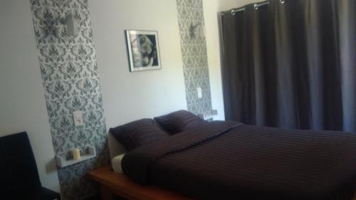 ein Schlafzimmer mit einem Bett und einem Fenster mit einem Vorhang in der Unterkunft T2 tout confort avec terrasse in Cransac