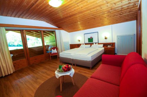 1 dormitorio con 1 cama y 1 sofá rojo en Gästehaus Hochkönig, en Filzmoos