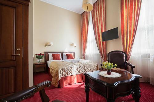 a hotel room with a bed and a chair and a table at Conviva in Panevėžys