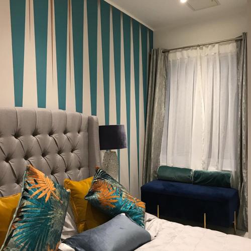a bedroom with a bed and a striped wall at 2 bed Chic Apartment in Glasgow City Centre in Glasgow