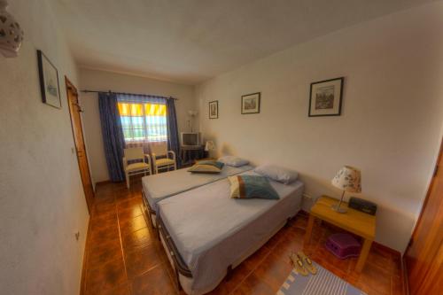 a bedroom with a bed and a table with a lamp at Casa da Ria Formosa in Cabanas de Tavira
