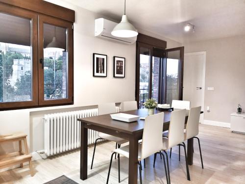 comedor con mesa de madera y sillas blancas en Leyenda de la Cava, en Toledo