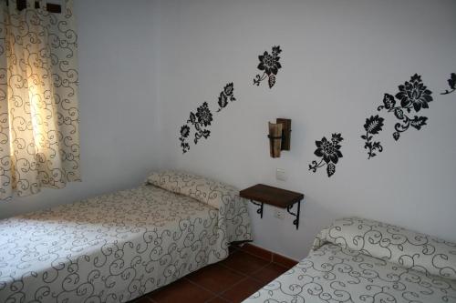 a bedroom with two beds and a table on the wall at Casa Rural La Posada Del Frances in Villarrubia de Santiago