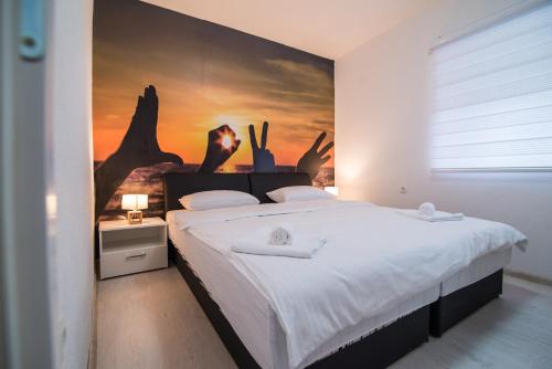 - une chambre avec un grand lit orné d'une peinture murale dans l'établissement Love Apartments, à Mostar