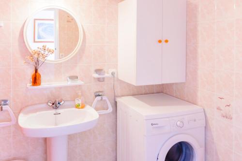 uma casa de banho com uma máquina de lavar roupa e um lavatório em SOL NAIXENT em Fornells