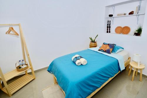 a bedroom with a large bed with blue sheets and a room with a ladder at Casa Sodadi in Praia