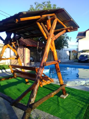 a wooden structure with a roof on the grass at CAZARE LA ESPAÑOLA in Haţeg