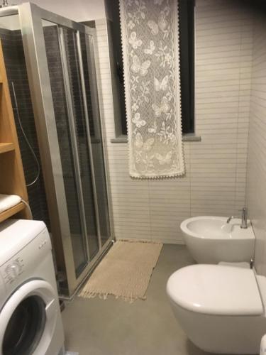 a bathroom with a toilet and a shower and a sink at cascina Filura in Mango