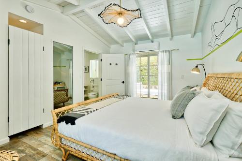 a bedroom with a large bed and a bathroom at Dive Palm Springs in Palm Springs