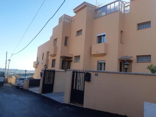 a building with a gate in front of it at Cozy rooms in terraced house in Fuengirola