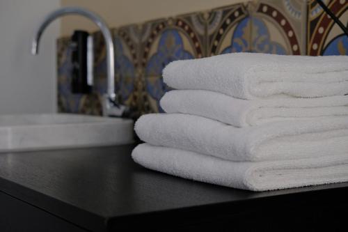 a stack of towels sitting on a counter next to a sink at Hotel Schöne Aussicht in Frankfurt/Main