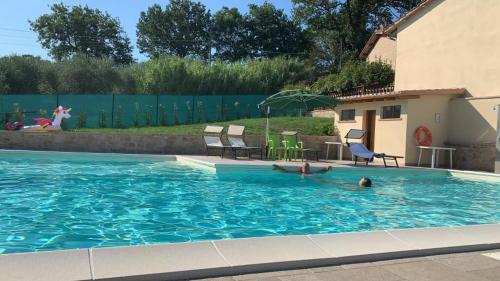 a swimming pool with two people in the water at Agriturismo Villalta in Ponte Felcino