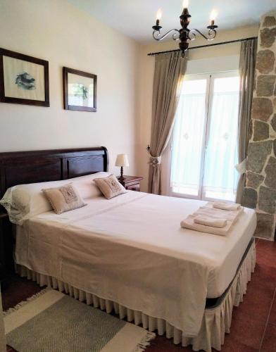a bedroom with a large bed and a window at Casa Sierra Norte Madrid in Lozoya