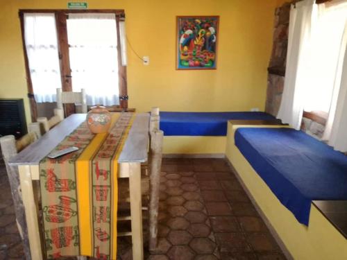 a room with a table and benches in a room at Establecimiento Rural El Chañar in San Rafael