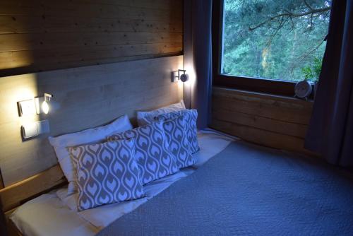 a room with a bed with two pillows and a window at Kaimo turizmo sodyba Geras in Leliūnai