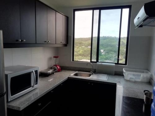 a kitchen with a microwave and a sink and a window at Edificio Nancabez III in Tonsupa