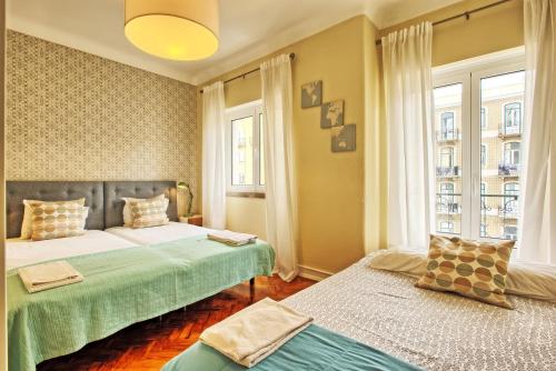リスボンにあるAlmirante 3-Four Bedroomsのベッドルーム1室(ベッド2台、窓2つ付)