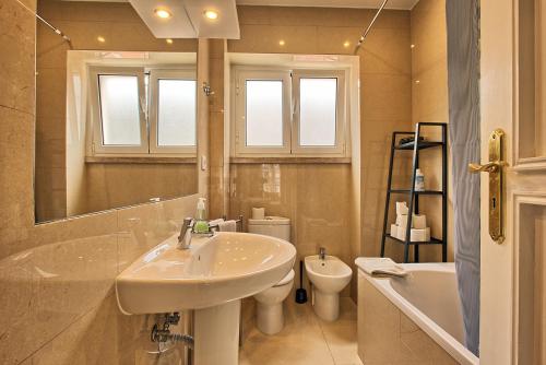 a bathroom with a sink and a toilet and a mirror at Almirante 3-Four Bedrooms in Lisbon