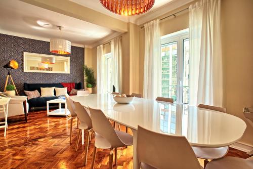 a dining room with a white table and chairs at Almirante 3-Four Bedrooms in Lisbon