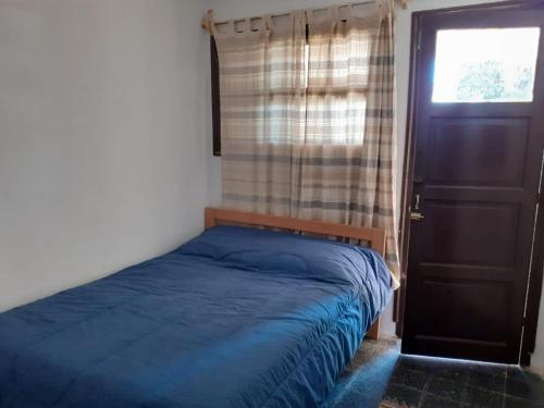 Schlafzimmer mit einem Bett, einem Fenster und einer Tür in der Unterkunft Precioso apartamento en el centro de La Paloma a menos de dos cuadras de la playa in La Paloma