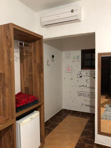 a room with a room with a fan and a wall at Pousada In Bali - Maresias in Maresias