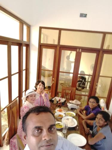 a group of people sitting around a table at Ever Green Villa in Negombo