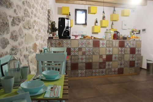 a kitchen with a table and chairs and a counter at Dimore San Nicola in Favara