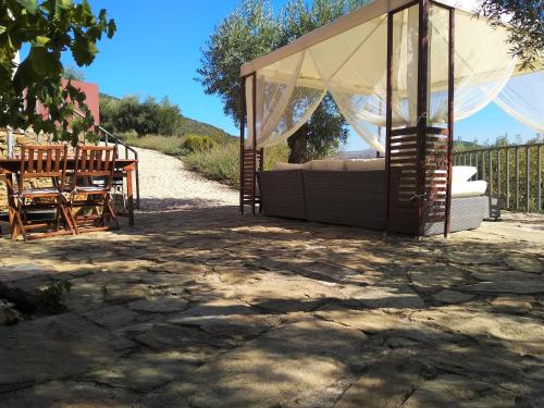 a gazebo with a couch and a table and chairs at Quinta Vale de Carvalho in Pinhal do Douro