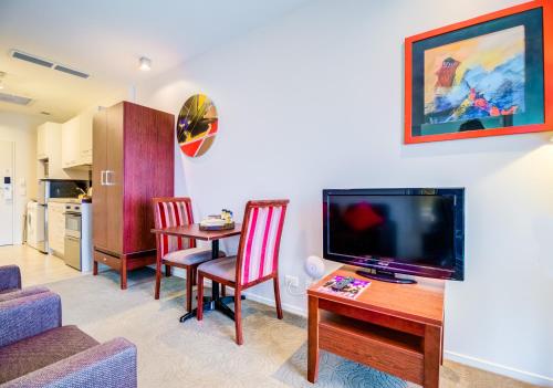 a living room with a table and a television at VR Auckland City in Auckland