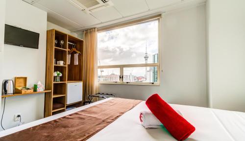 a bedroom with a large window and a bed with a red pillow at Ascotia Off Queen in Auckland
