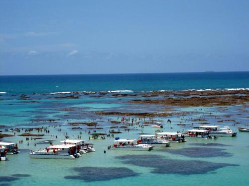 a group of boats in the water at the beach at Suítes&Flats MarBello in Maragogi