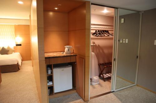 a bathroom with a sink and a dresser at Hotel Associa Shizuoka in Shizuoka