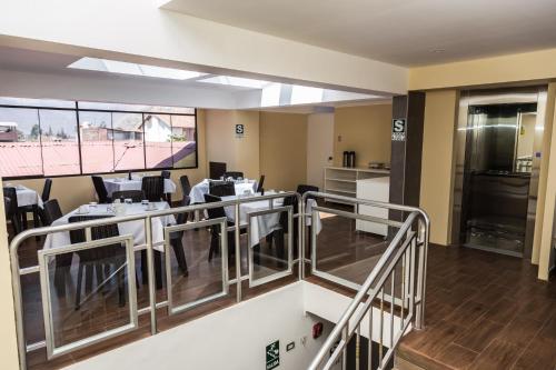a view of a room with chairs and a kitchen at Hotel Andes de Urubamba in Urubamba