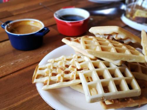 two waffles on a plate on a table with syrup at Hotel Jardin Atacama in San Pedro de Atacama