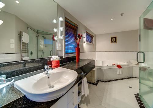 a bathroom with a sink and a bath tub at VR Rotorua Lake Resort in Rotorua