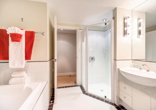 a bathroom with a shower and a sink at VR Rotorua Lake Resort in Rotorua