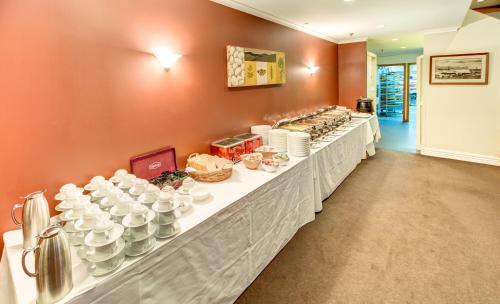 a long buffet line with white plates and bowls at VR Rotorua Lake Resort in Rotorua