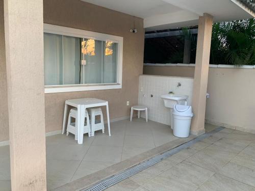 a bathroom with a toilet and a sink and a table at Casa Búzios - Temporada in Búzios