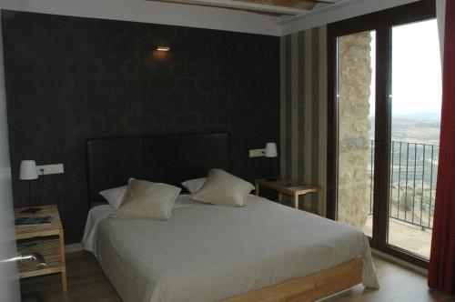 a bedroom with a white bed and a large window at Casa Rural Virginia in Ares del Maestre