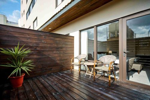 a wooden deck with a table and chairs on it at 雀客旅館台中來來 in Taichung
