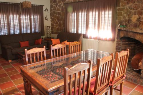 sala de estar con mesa de cristal y sillas en El Rincón Del Juez, en Uña