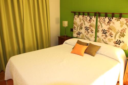 a bedroom with a white bed with two pillows at El Rincón Del Juez in Uña